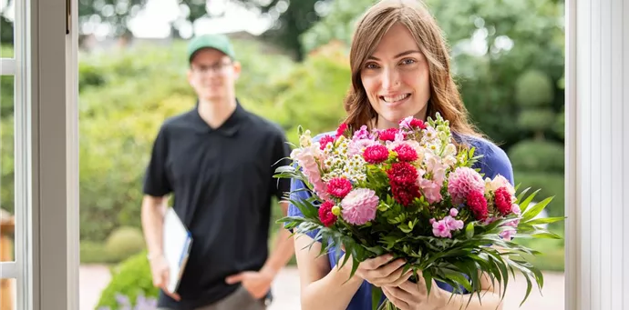 Lieferservice - Frau erhält Blumenpräsent